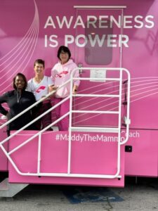 Women smiling in front of pink truck