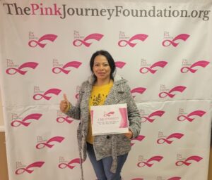 women giving a thumbs up in front of pink journey backdrop